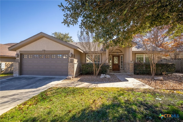 single story home with stucco siding, stone siding, fence, concrete driveway, and a garage