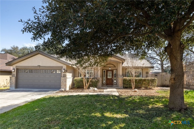 view of front of home with stucco siding, driveway, a front lawn, fence, and an attached garage