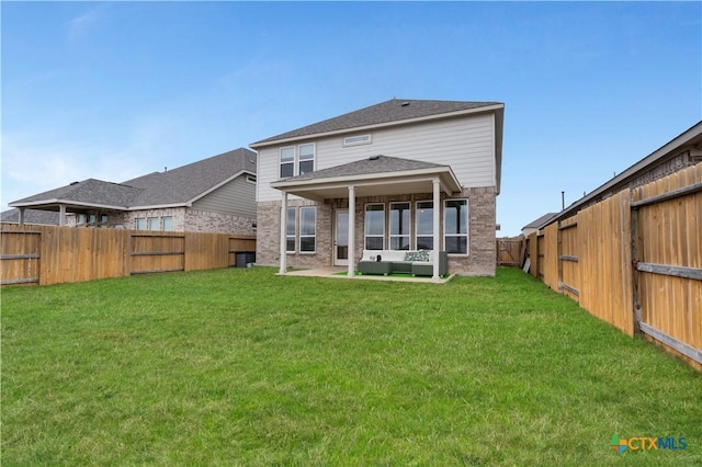 back of house featuring a lawn and a patio