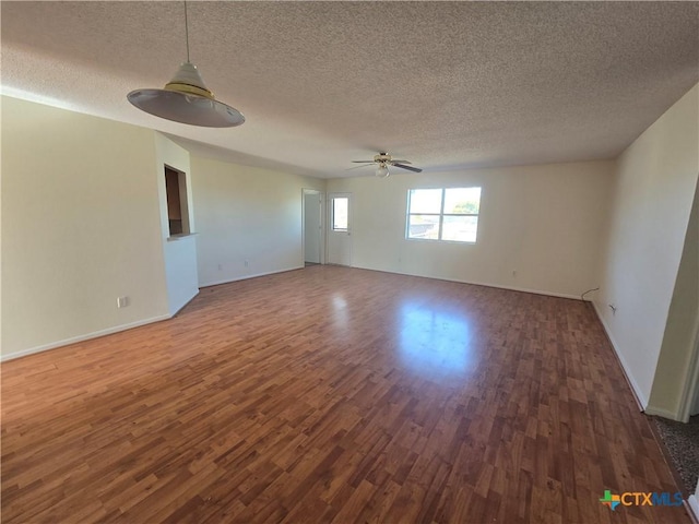 unfurnished room with ceiling fan, a textured ceiling, and dark hardwood / wood-style flooring