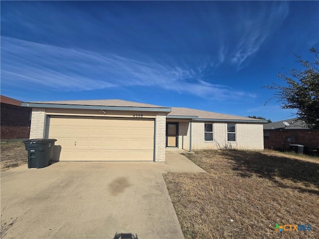 single story home featuring a garage and central air condition unit