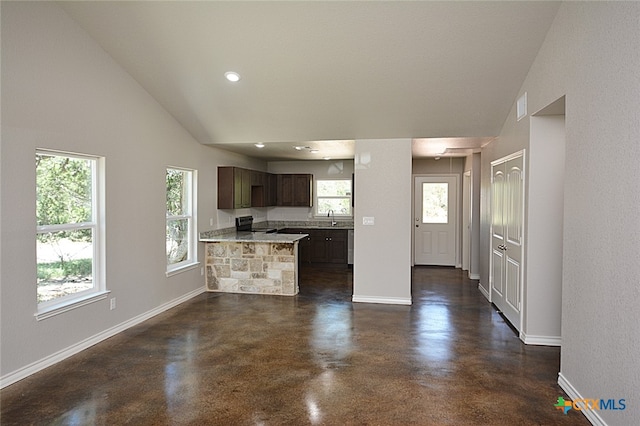 kitchen with dark brown cabinetry, sink, kitchen peninsula, lofted ceiling, and electric stove