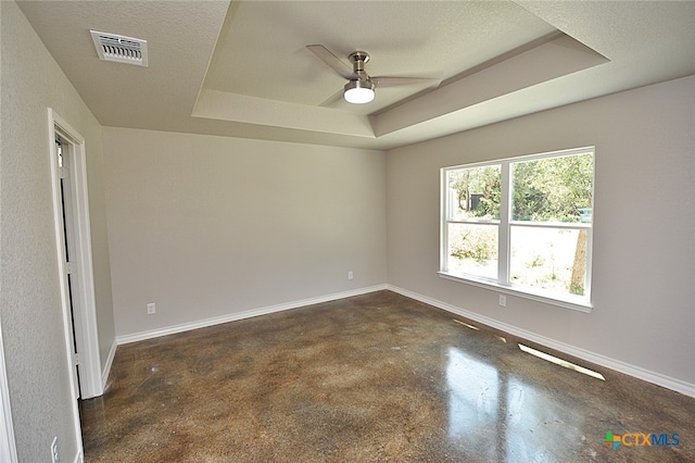 spare room featuring a textured ceiling, a raised ceiling, and ceiling fan