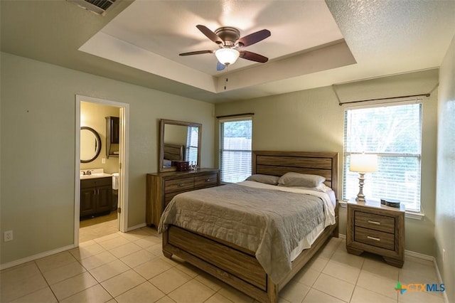 408 Sterling Manor Ct, Temple, TX 76502 - bedroom with a tray ceiling, light tile patterned flooring, ensuite bath, and ceiling fan