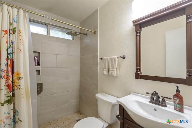 408 Sterling Manor Ct, Temple, TX 76502 - bathroom featuring a tile shower, vanity, a textured wall, and speckle patterned floor
