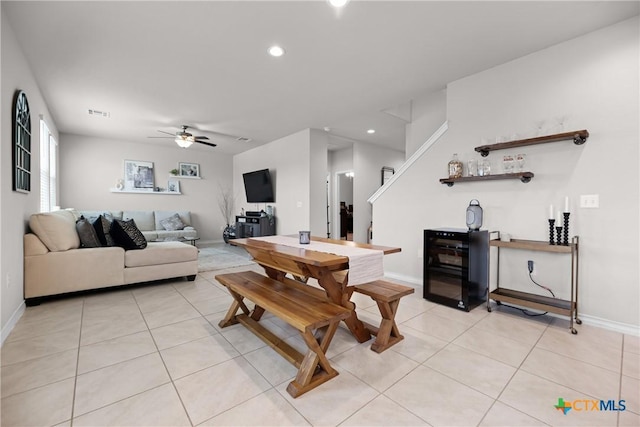 living room with light tile patterned floors, baseboards, and a ceiling fan