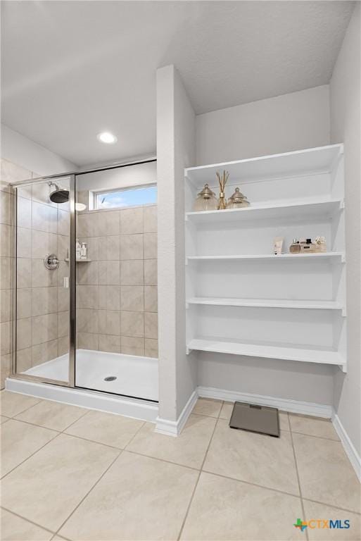 full bath featuring baseboards, a stall shower, and tile patterned flooring