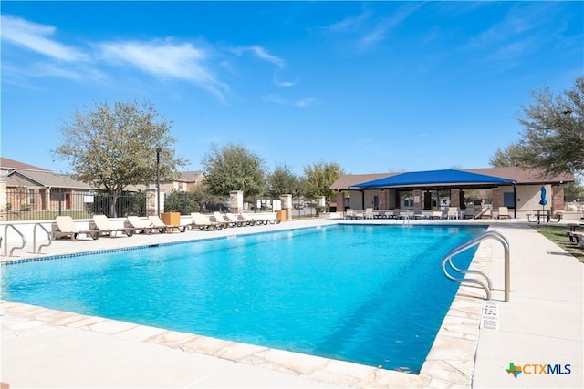 pool with a patio and fence