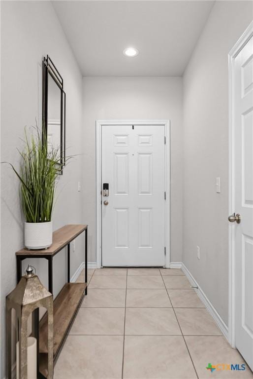 entryway with recessed lighting, baseboards, and light tile patterned flooring