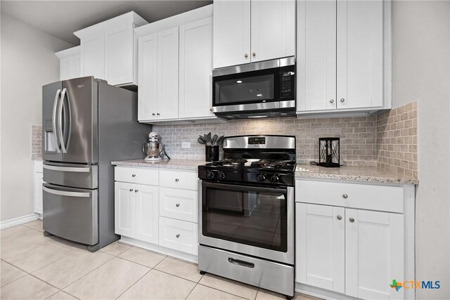 kitchen featuring white cabinetry, light tile patterned floors, backsplash, and stainless steel appliances