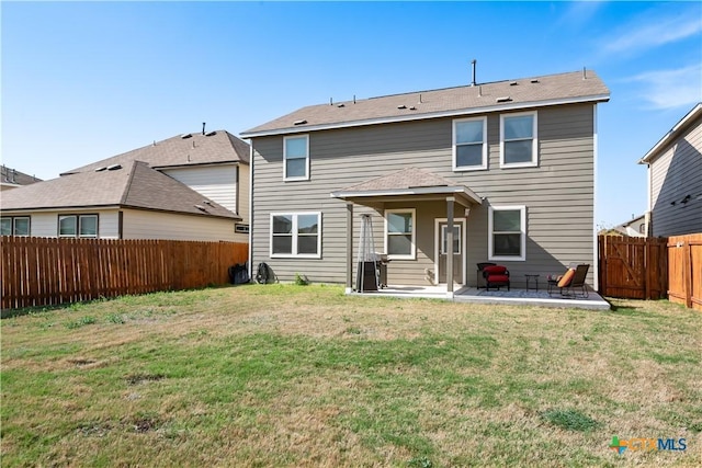 back of house with a patio, a lawn, and a fenced backyard