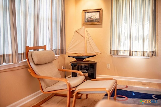 living area featuring baseboards and wood finished floors