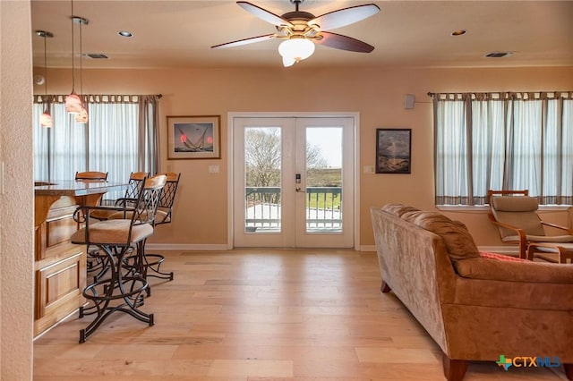 living room featuring french doors, light wood-style flooring, visible vents, and a healthy amount of sunlight