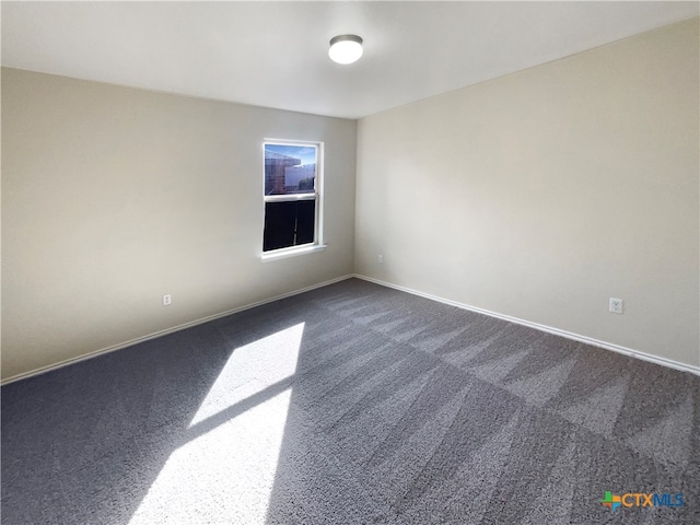 unfurnished room with dark colored carpet