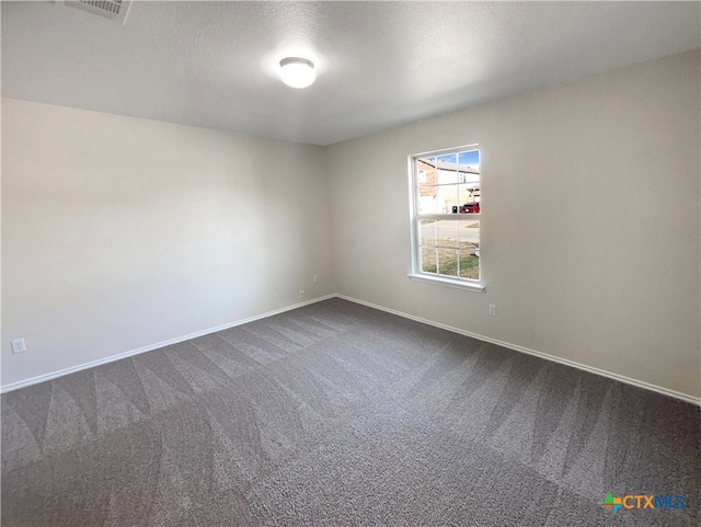 carpeted empty room with a textured ceiling