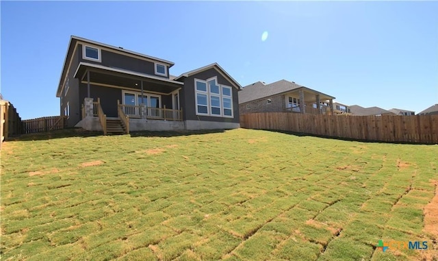 rear view of property with a lawn