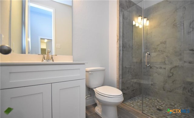 bathroom featuring vanity, an enclosed shower, and toilet