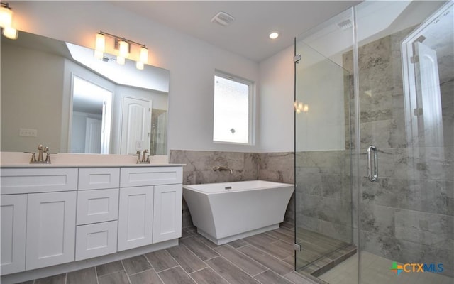 bathroom with vanity, tile walls, and shower with separate bathtub