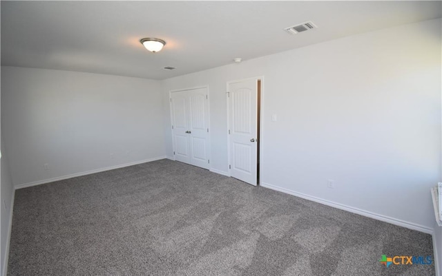 empty room with dark colored carpet