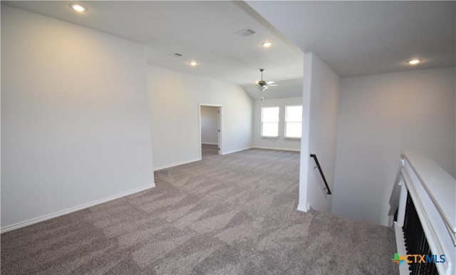 carpeted spare room with ceiling fan and vaulted ceiling