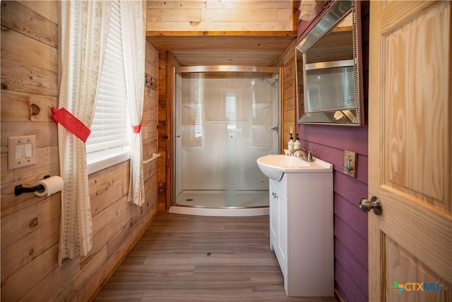 126 Washington Ave, Port Lavaca, TX 77979 - full bathroom with wooden walls, a stall shower, vanity, wood finished floors, and plenty of natural light