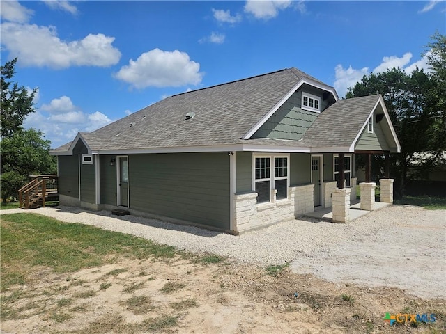 905 Roadrunner Spur, Canyon Lake, TX 78133 - rear view of property with a shingled roof, covered porch, and stone siding