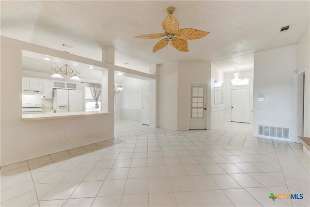 tiled empty room featuring a textured ceiling and ceiling fan