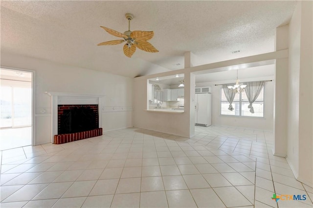 unfurnished living room featuring a fireplace, light tile patterned floors, ceiling fan with notable chandelier, and vaulted ceiling