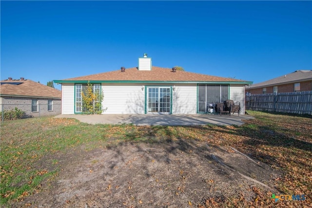 rear view of property with a lawn and a patio