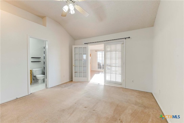 carpeted spare room featuring ceiling fan and lofted ceiling