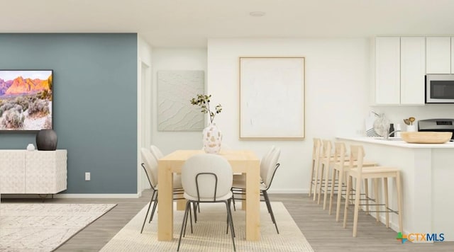 dining room featuring baseboards and wood finished floors