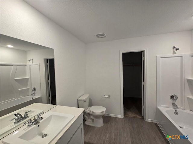 209 Tugboat Annie Way, Jarrell, TX 76537 - bathroom featuring wood finished floors, vanity, toilet, tub / shower combination, and a spacious closet