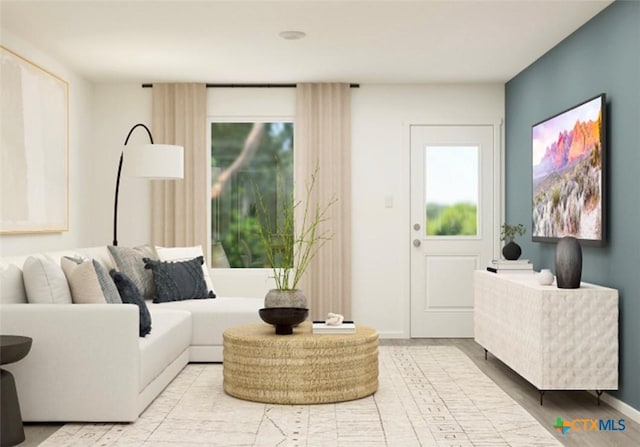 living room featuring baseboards and a healthy amount of sunlight