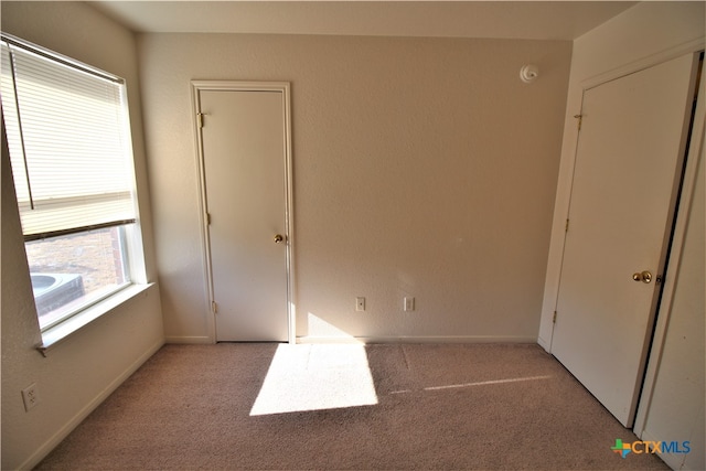 unfurnished bedroom with light colored carpet