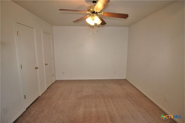 carpeted spare room with ceiling fan