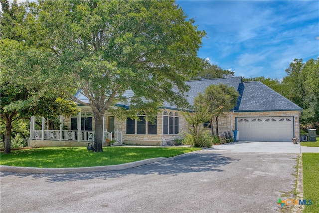 view of front of property with a front lawn, a garage, and covered porch