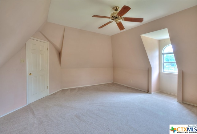 bonus room with lofted ceiling, light carpet, and ceiling fan