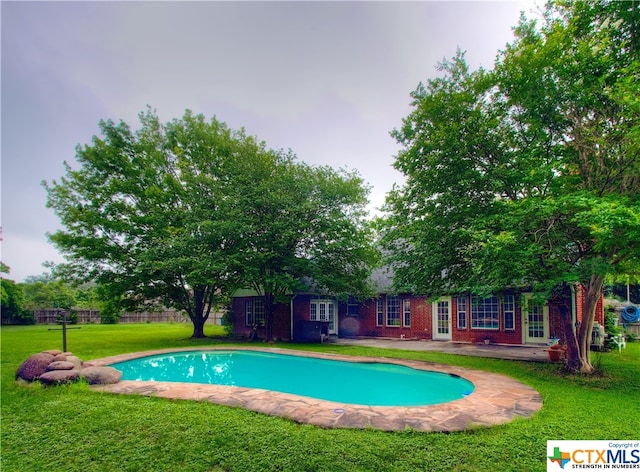 view of pool featuring a lawn and a patio