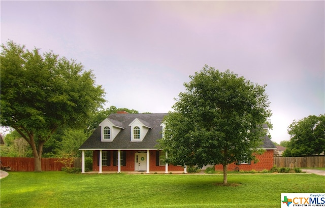 new england style home with a porch and a yard