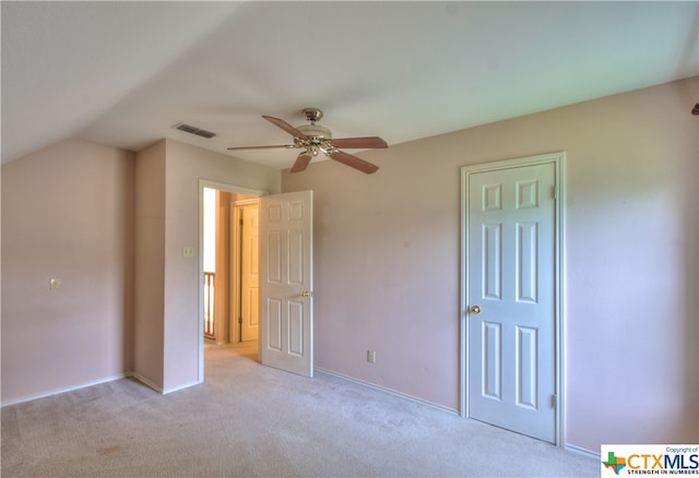 unfurnished bedroom featuring light colored carpet, lofted ceiling, and ceiling fan