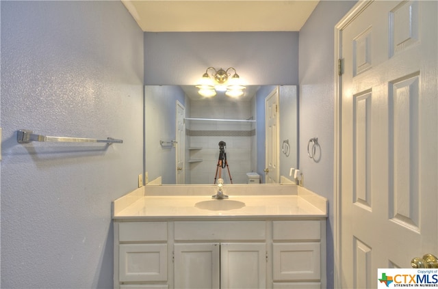 bathroom featuring walk in shower and vanity