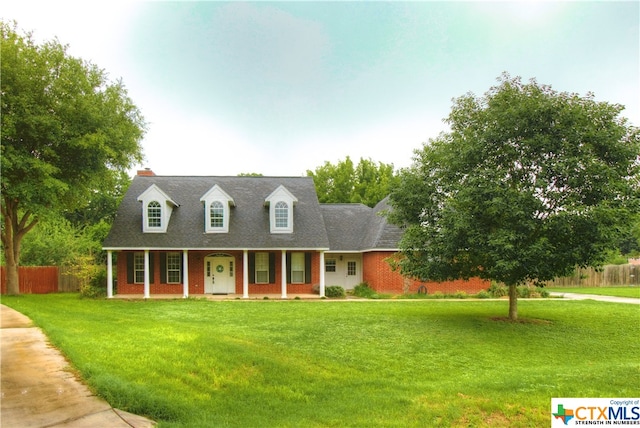 new england style home with a front yard and covered porch