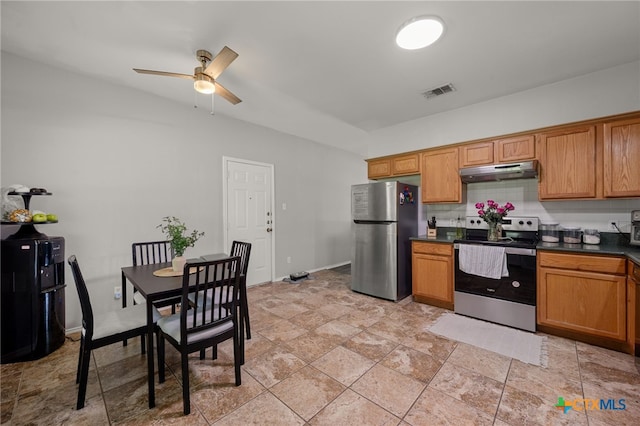 1503 Prather St, Taylor, TX 76574 - kitchen with stainless steel appliances, under cabinet range hood, dark countertops, a ceiling fan, and brown cabinets