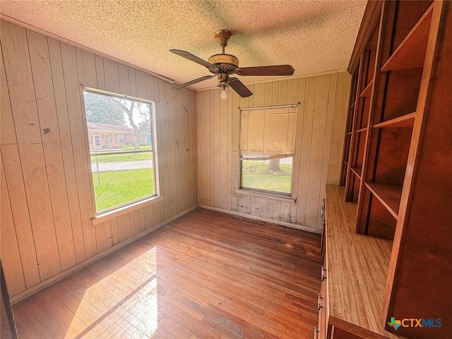 1606 Milam Dr, Victoria, TX 77901 - empty room featuring wood finished floors, a textured ceiling, ceiling fan, and wooden walls