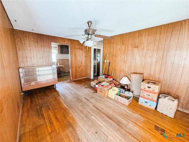 1606 Milam Dr, Victoria, TX 77901 - spare room with hardwood / wood-style floors, wooden walls, a textured ceiling, and a ceiling fan
