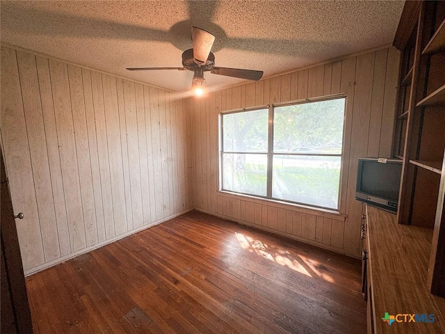 1606 Milam Dr, Victoria, TX 77901 - empty room featuring hardwood / wood-style floors, wood walls, a ceiling fan, and a textured ceiling