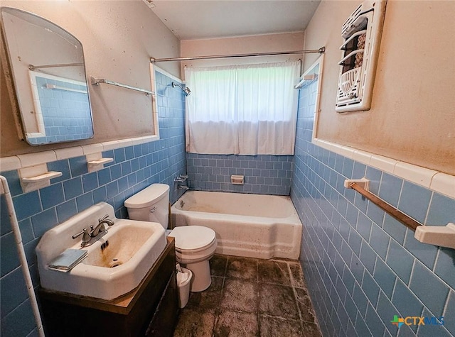 1606 Milam Dr, Victoria, TX 77901 - full bathroom with tile walls, shower / tub combination, vanity, a wainscoted wall, and stone finish flooring