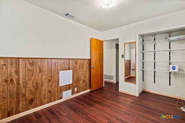 201 S Barbara St, Waco, TX 76705 - unfurnished bedroom featuring wood finished floors, a closet, and wooden walls