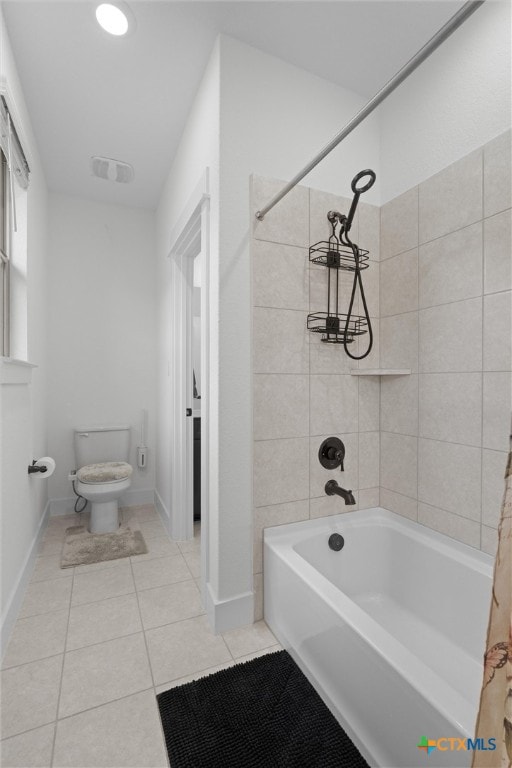 bathroom featuring tile patterned floors, toilet, and tiled shower / bath combo