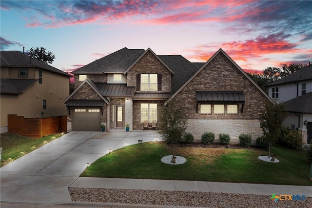 1604 Hinterwald St, Leander, TX 78641 - view of front facade featuring a standing seam roof, driveway, a front lawn, a garage, and a shingled roof